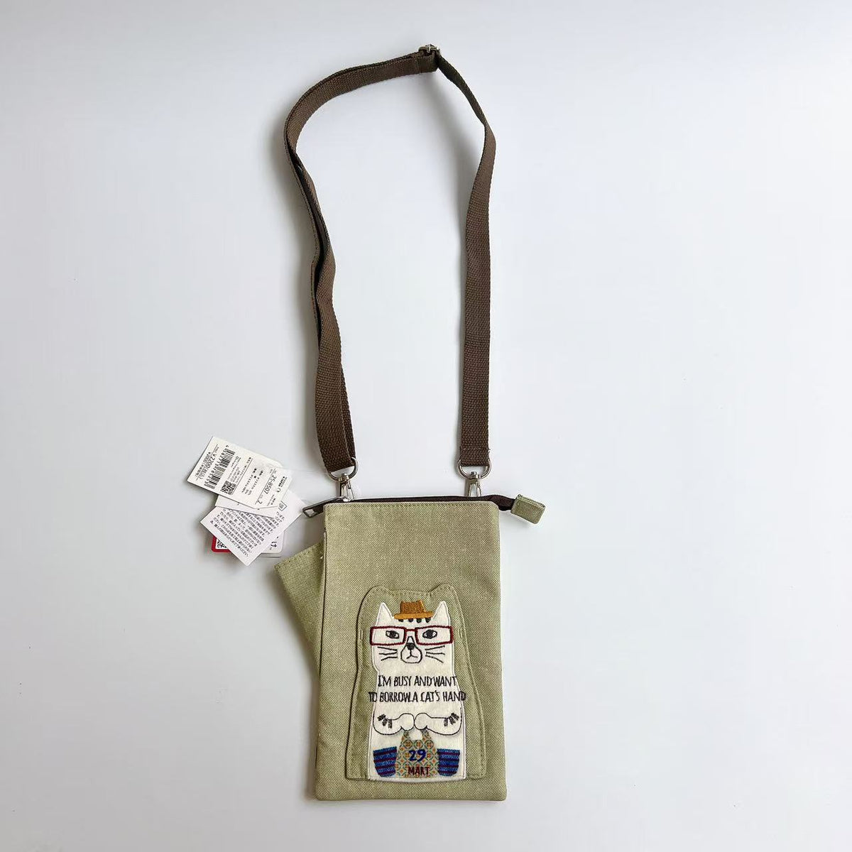 日本Kusuguru正品刺繡眼鏡貓手機包布藝斜背包傳輸線耳機包400｜眼鏡貓米黃8507-2